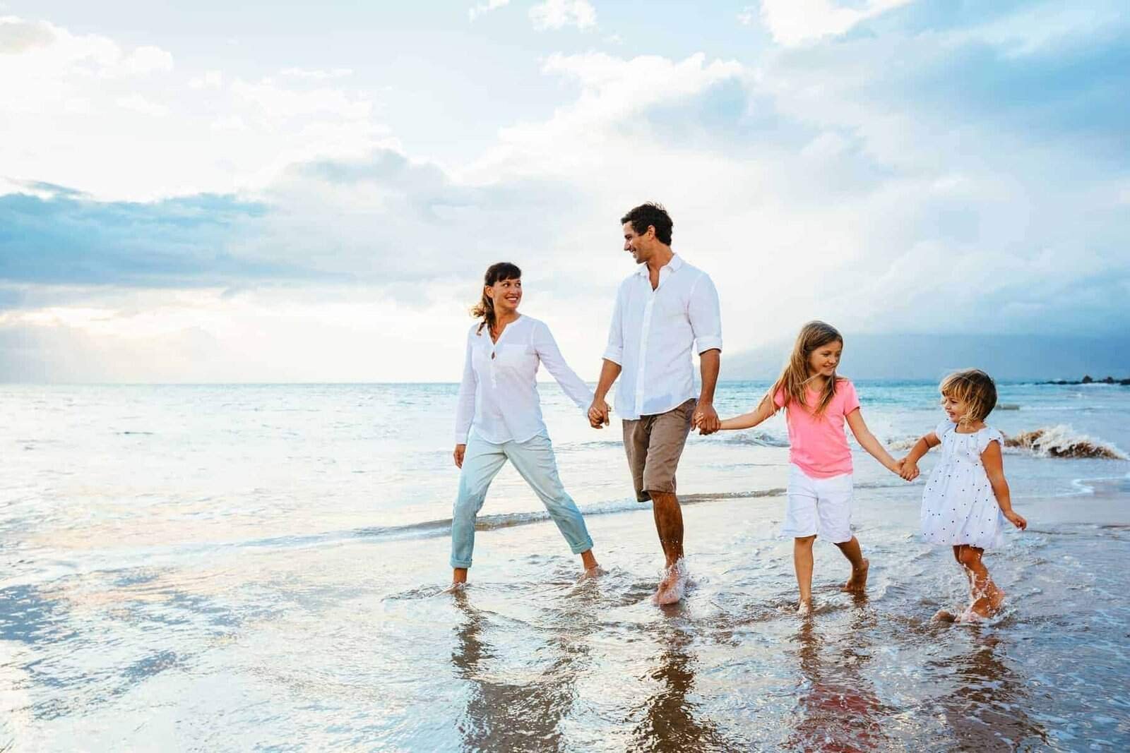 Happy young family walking on the beach at sunset. Happy Family Lifestyle