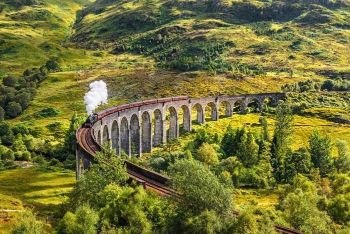 Glenfinnan Railway Viaduct in Scotland with a steam train