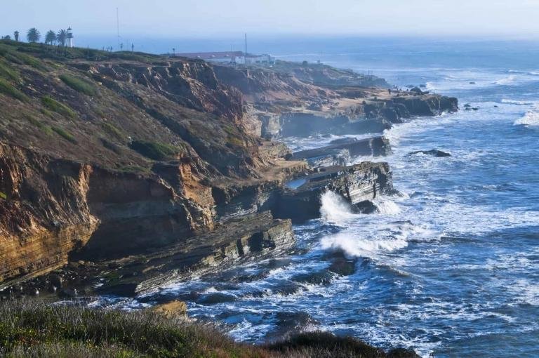 The rugged coastline cliffs of the Pacific Ocean in San Diego, southern California, on the west coast of the United States, at Point Loma in Cabrillo National Monument with a rough surf on a misty afternoon.