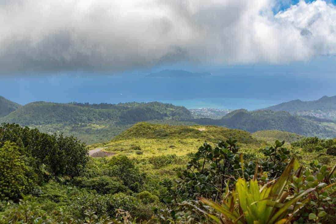 Idyllic panoramic view of lush green vegetation and Caribbean sea in the tropical island Guadeloupe. Town Basse Terre in background.