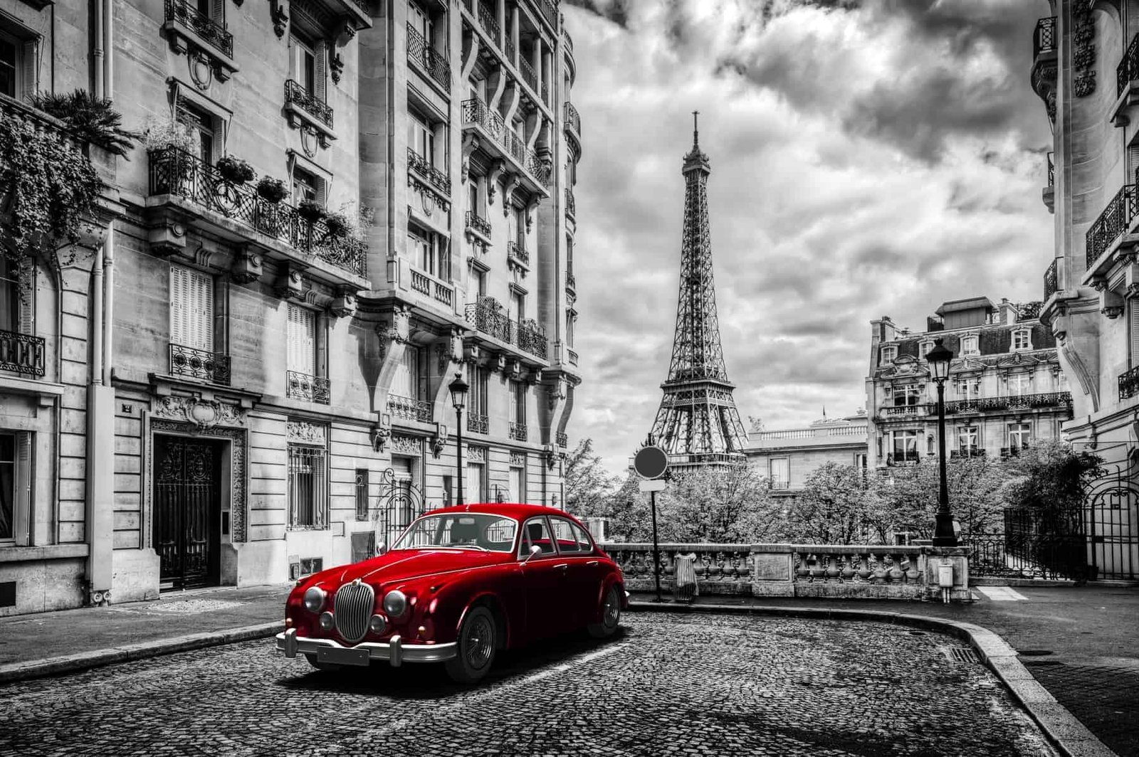 Paris, France. Eiffel Tower seen from the street with red retro limousine car. Black and white unique vintage composition.
