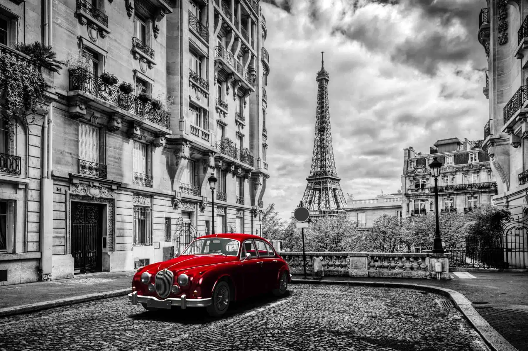 Paris, France. Eiffel Tower seen from the street with red retro limousine car. Black and white unique vintage composition.
