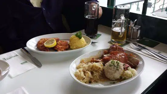 Delicious traditional German food with schnitzel, mashed potatoes, and roast meats at a restaurant.