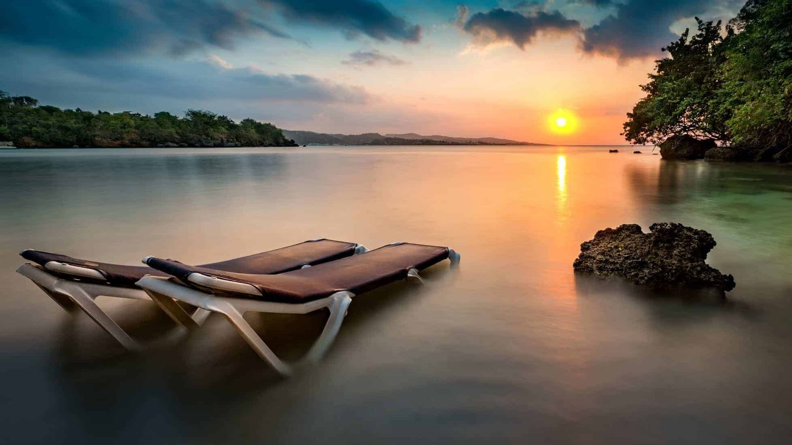 Sunset with beach chairs on a tropical beach in Jamaica.