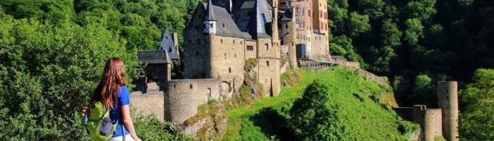 Young woman standing at the overlook of Eltz Castle in Rhineland-Palatinate, Germany. It was built in the 12th century and has never been destroyed.