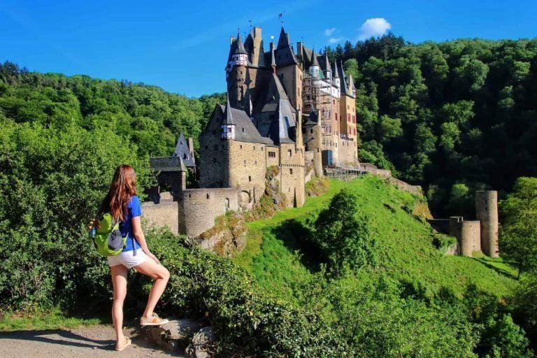 Young woman standing at the overlook of Eltz Castle in Rhineland-Palatinate, Germany. It was built in the 12th century and has never been destroyed.