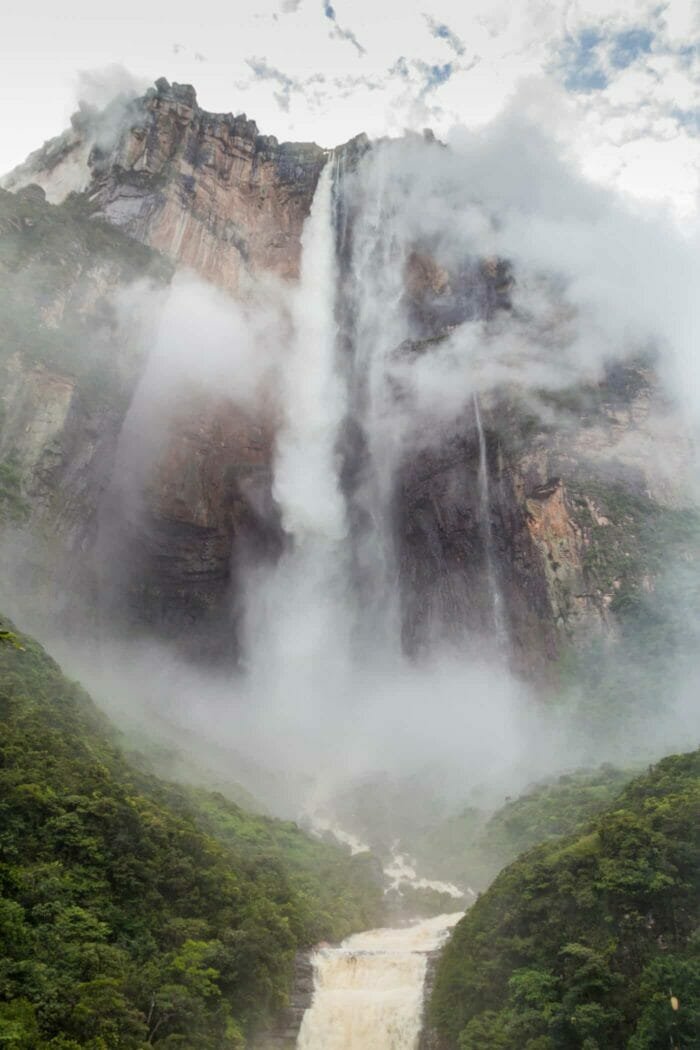 Majestic mountain with waterfall and lush greenery, perfect for nature travel adventures.