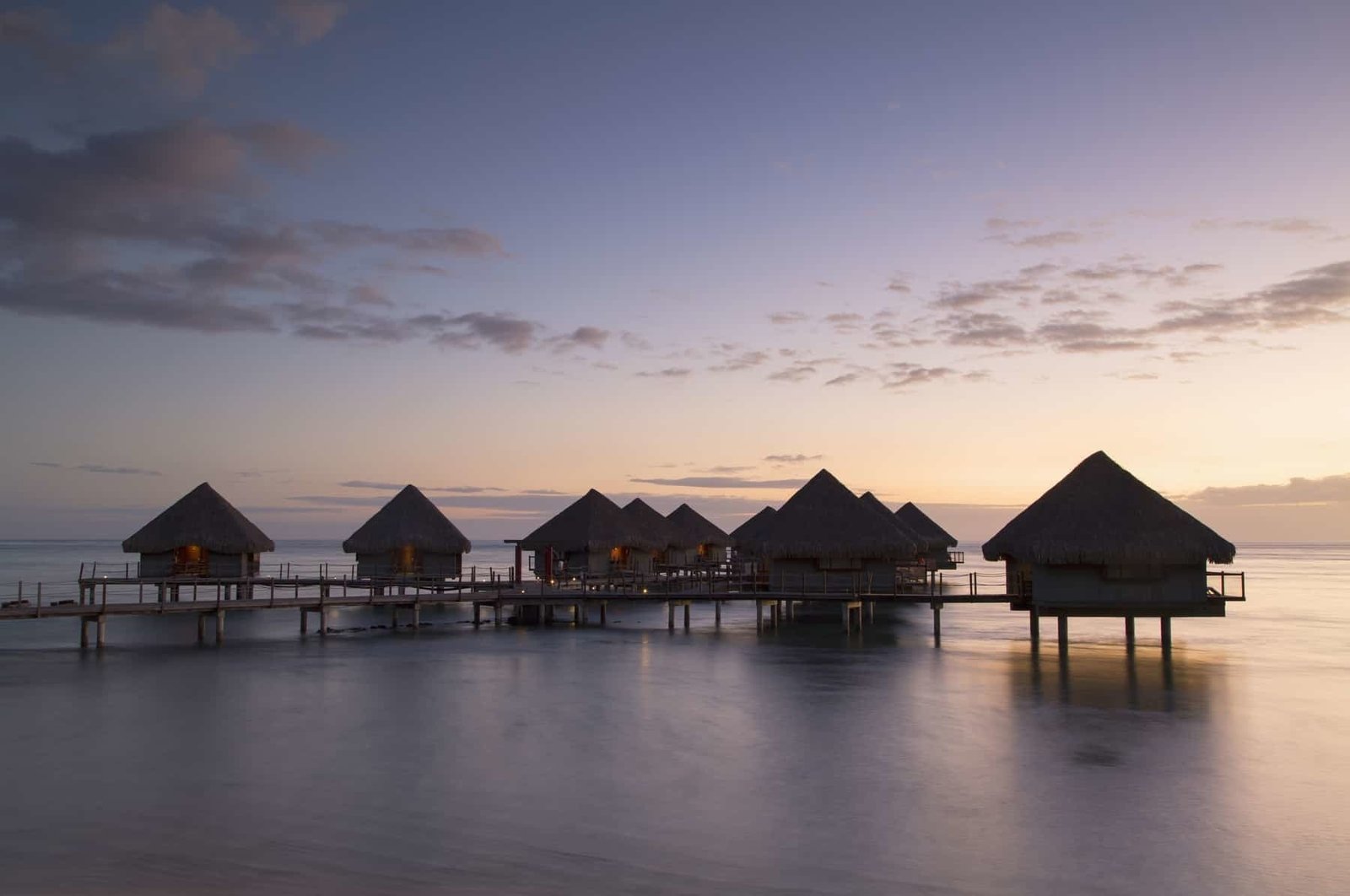 View of overwater bungalows at Le Meridien Tahiti Hotel at sunset, Pape'ete, Tahiti, French Polynesia