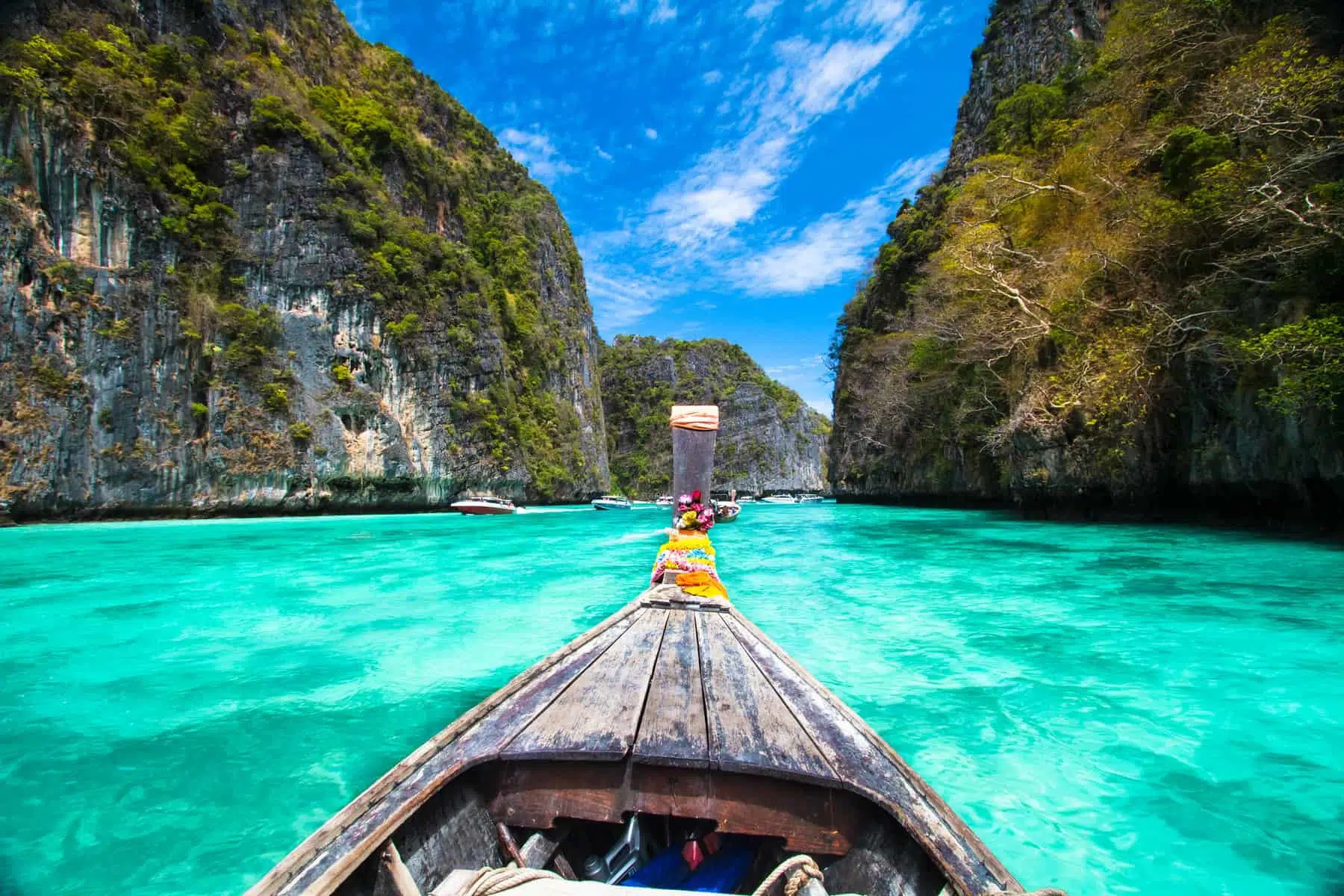 Lush green island with white sandy beach and turquoise waters, popular vacation destination in Thailand.