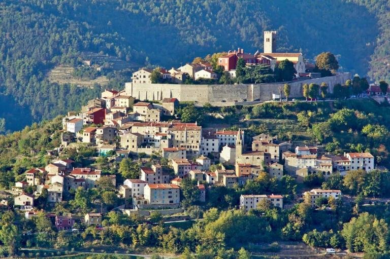 Picturesque hillside village with historic castle and colorful houses in Tuscany, Italy.