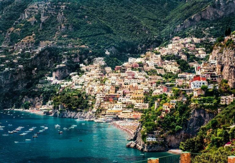 Colorful coastal town nestled on steep hillside overlooking the Mediterranean Sea.