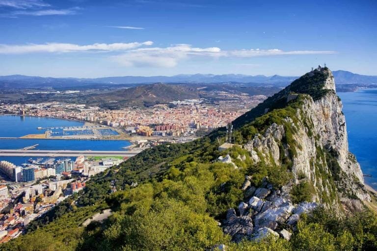 Cliffs of Gibraltar overlooking the city and coastline on a bright sunny day.