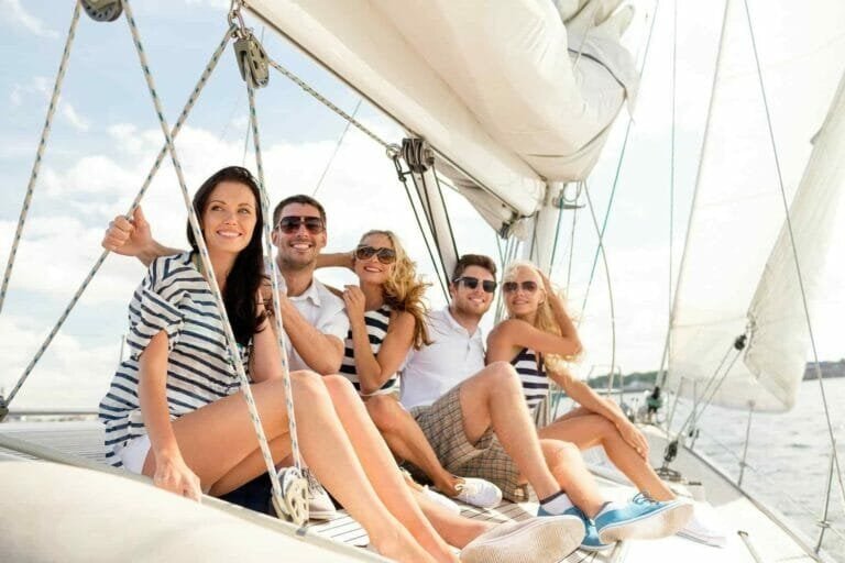 smiling friends sitting on yacht deck