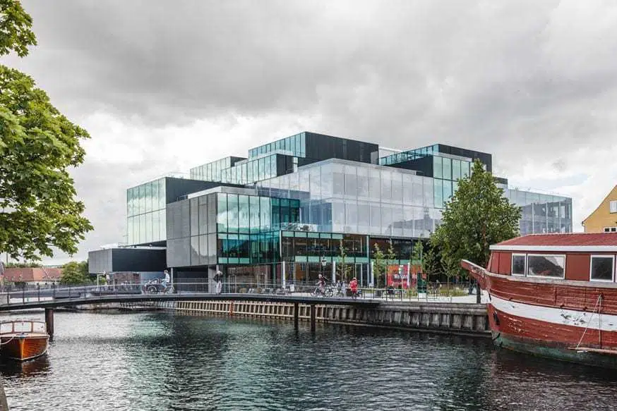 Eco-friendly hotel building with green rooftop gardens in an urban setting, promoting sustainable tourism.
