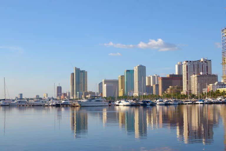 manila bay city scape with yachts and luxury boats on summer afternoon.