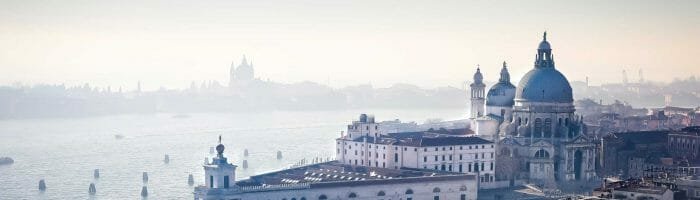 Historic Venice skyline with domed churches and scenic waterfront views, perfect for travel and vacation enthusiasts.