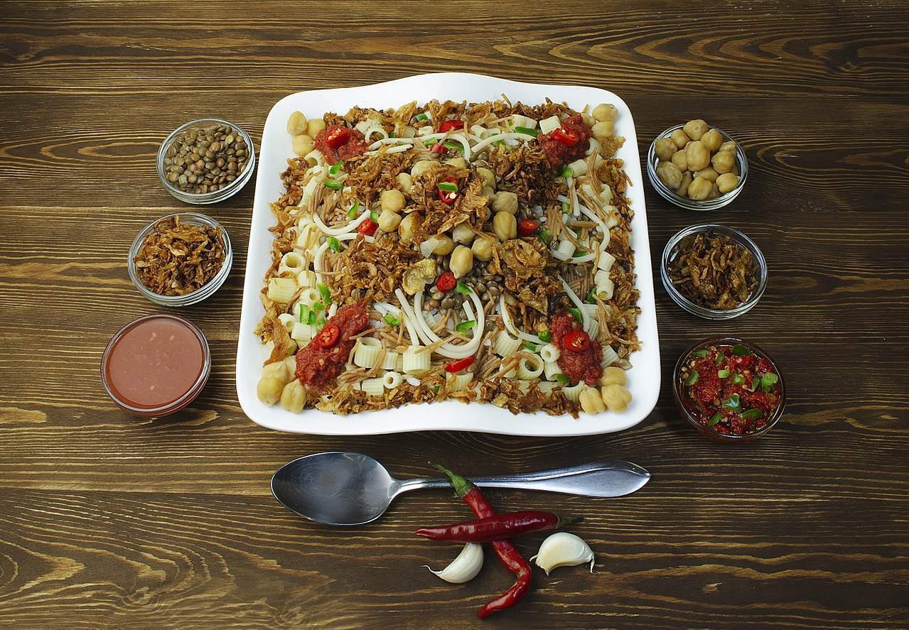 Spicy Indonesian lontong with various side dishes on a wooden table, traditional festive Indonesian cuisine.