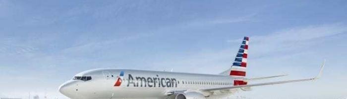 American Airlines airplane on snowy runway with clear blue sky, promoting travel and vacation destinations.