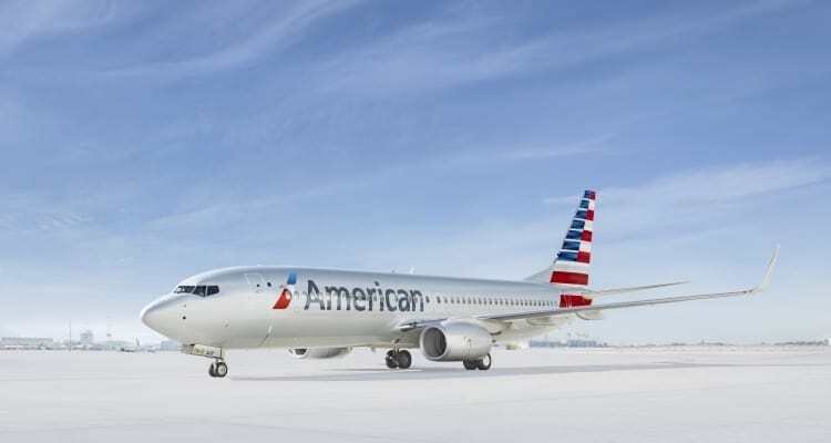 American Airlines airplane on snowy runway with clear blue sky, promoting travel and vacation destinations.