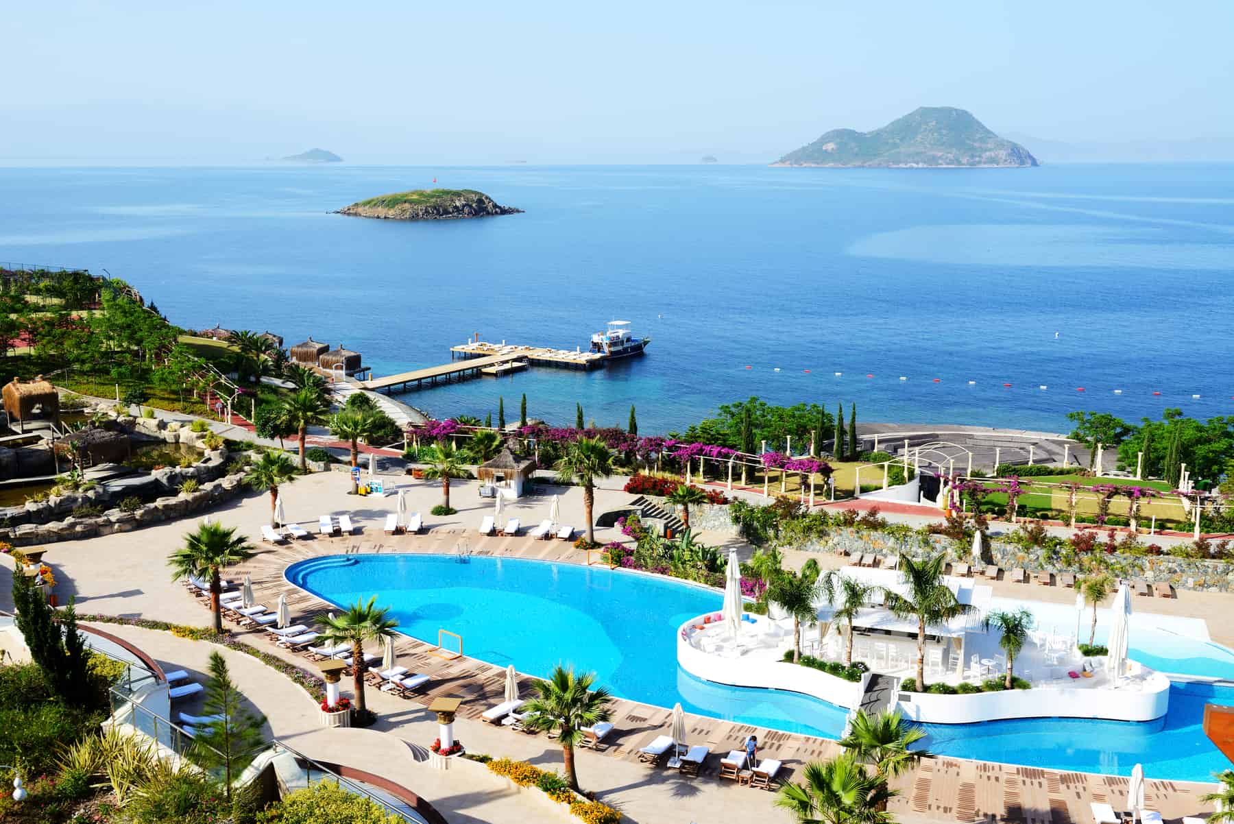 Luxurious seaside resort with infinity pool overlooking the ocean and tropical garden, perfect for vacation staycations.