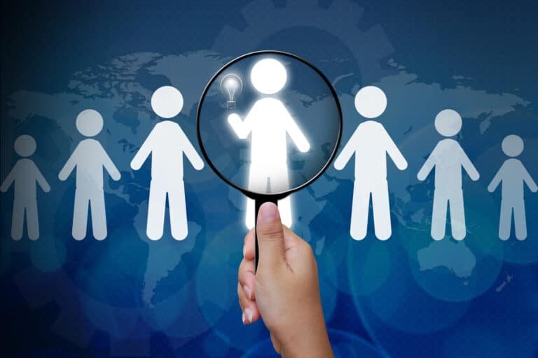 Magnifying glass highlighting a person among digital icons representing global travel and tourism.