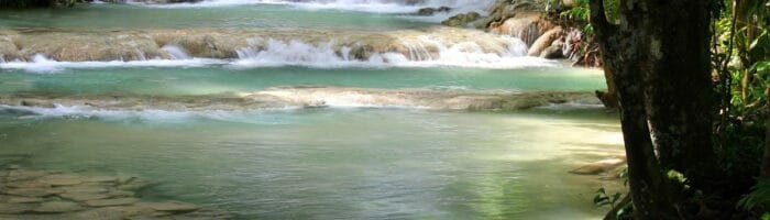 Tranquil waterfall cascading over rocks in lush jungle setting, perfect for nature travel inspiration.