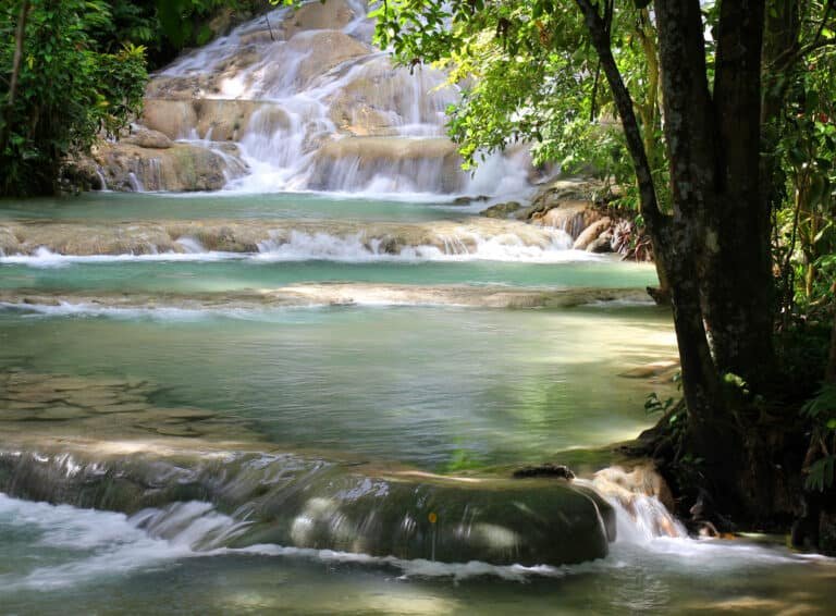 Tranquil waterfall cascading over rocks in lush jungle setting, perfect for nature travel inspiration.