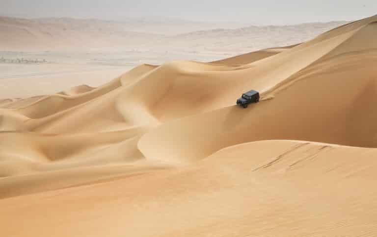 The best reason to travel to Oman is the luxury and beaches, but do not forget the beauty of the desert and the mountains. Oman has a different offers from relaxing beach comfort to adventures in a very different nature.. car driving in Rub al Khali Desert at the Empty Quarter, in Abu
