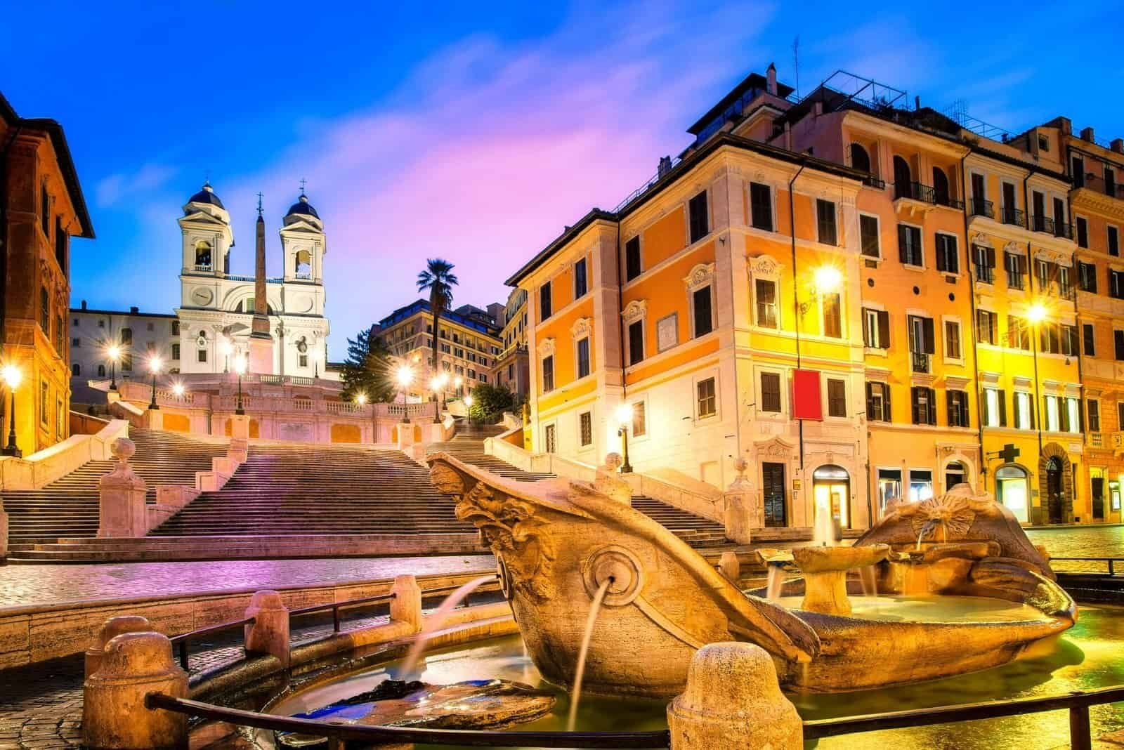 Rome, Italy. Fountain of the Boat (Fontana della Barcaccia) on Spanish square (Piazza di Spagna) at the bottom of Spanish stairs famous landmark design by Bernini. Summer day and blue sky with clouds.