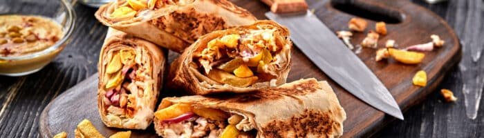 Middle Eastern Cuisine Chicken Shawarma, Pita Sandwich, roll in a pita with fresh vegetables, cream sauce and french fries