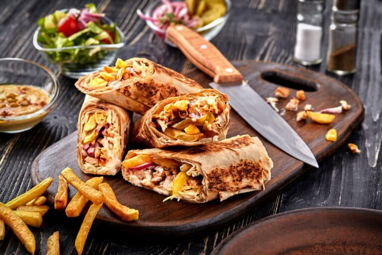 Middle Eastern Cuisine Chicken Shawarma, Pita Sandwich, roll in a pita with fresh vegetables, cream sauce and french fries