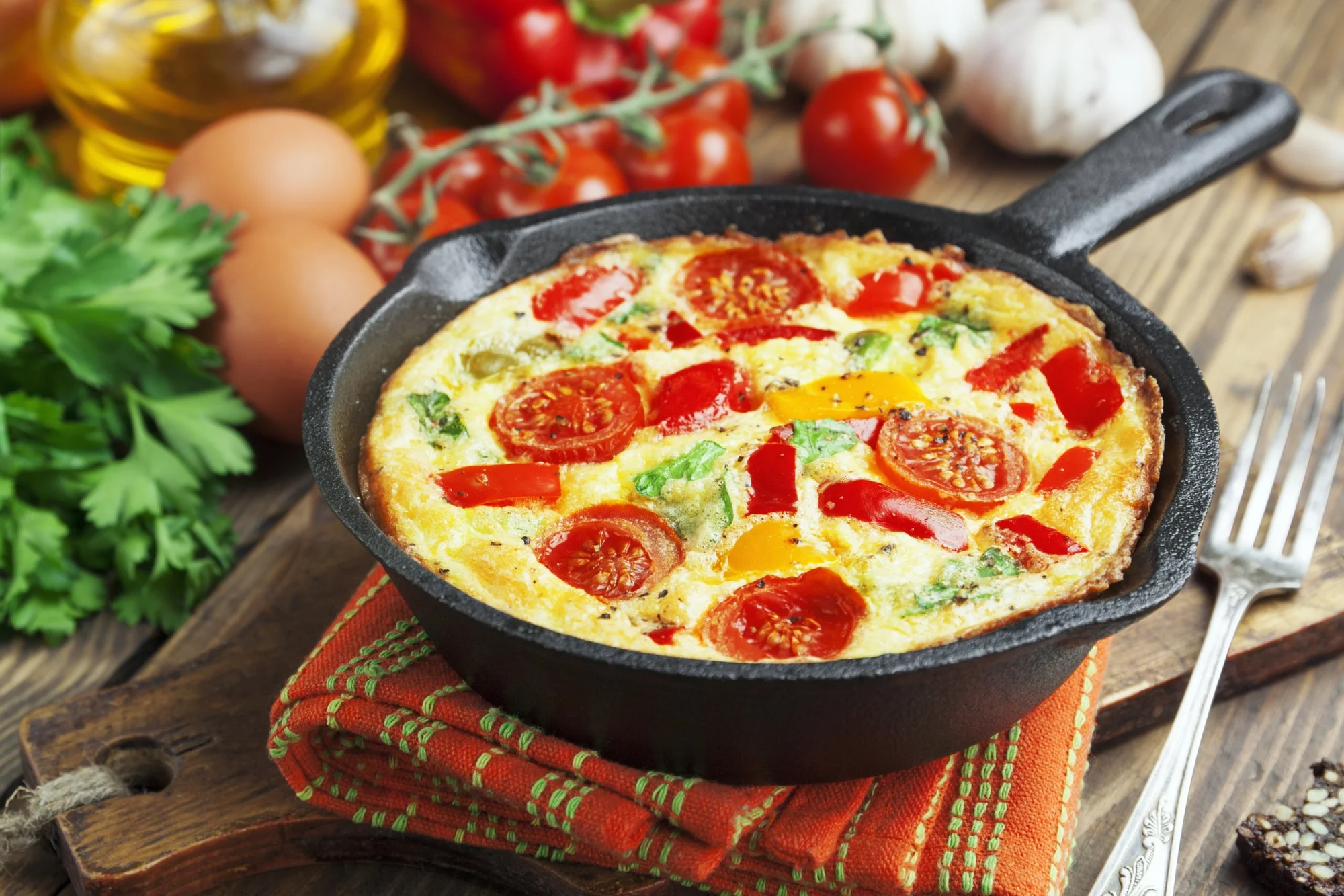 Omelet with vegetables and cheese. Frittata in a frying pan