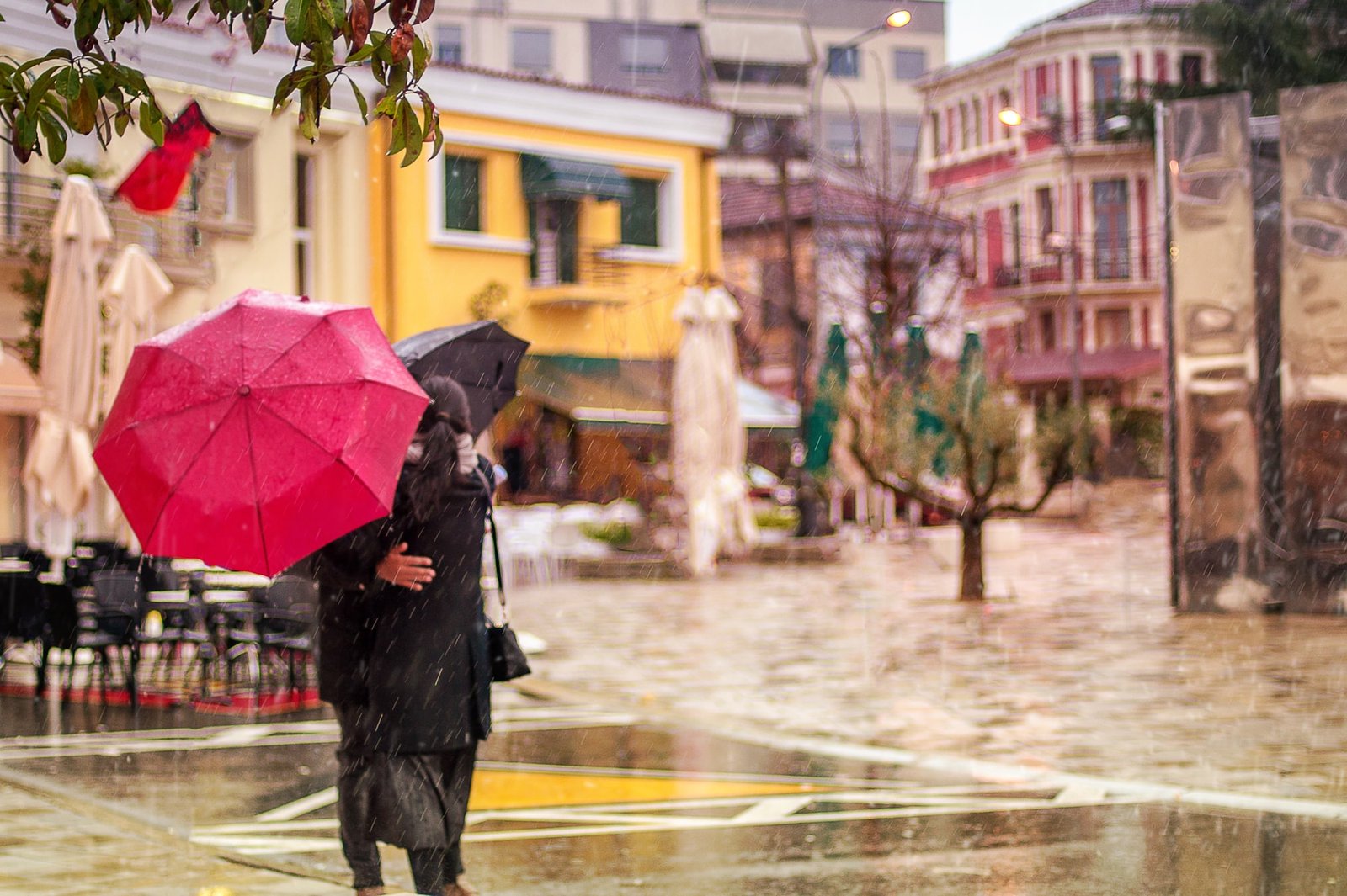 A pair hugging in a street under the rain in Paris