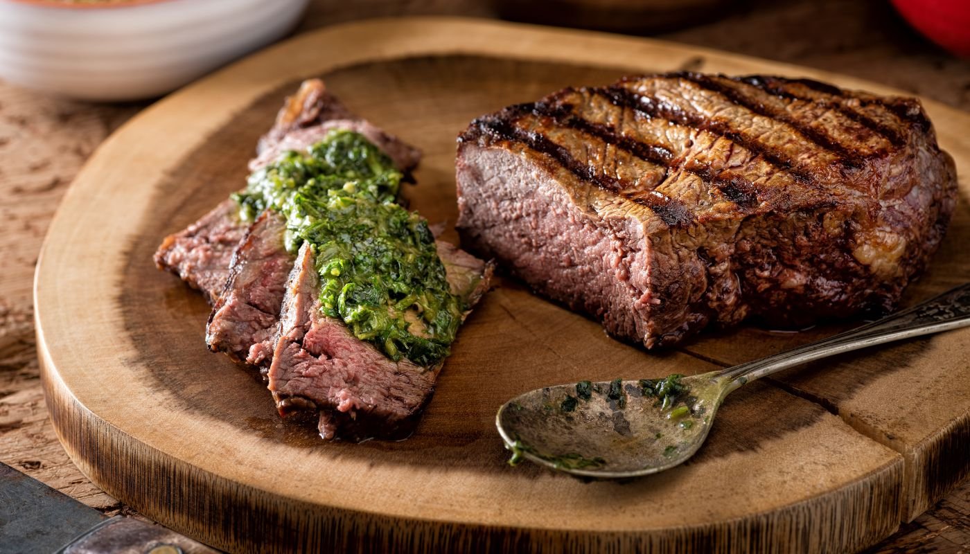 Food and wine culture in Argentina. Tasty Argentine steak in Chimichurri sauce.