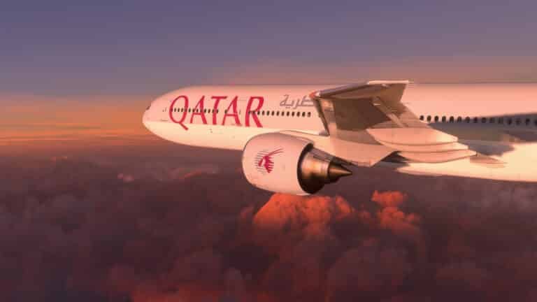 Fly first class. Boeing 777 Qatar Airways flying over the amazing sunset, Doha, Qatar