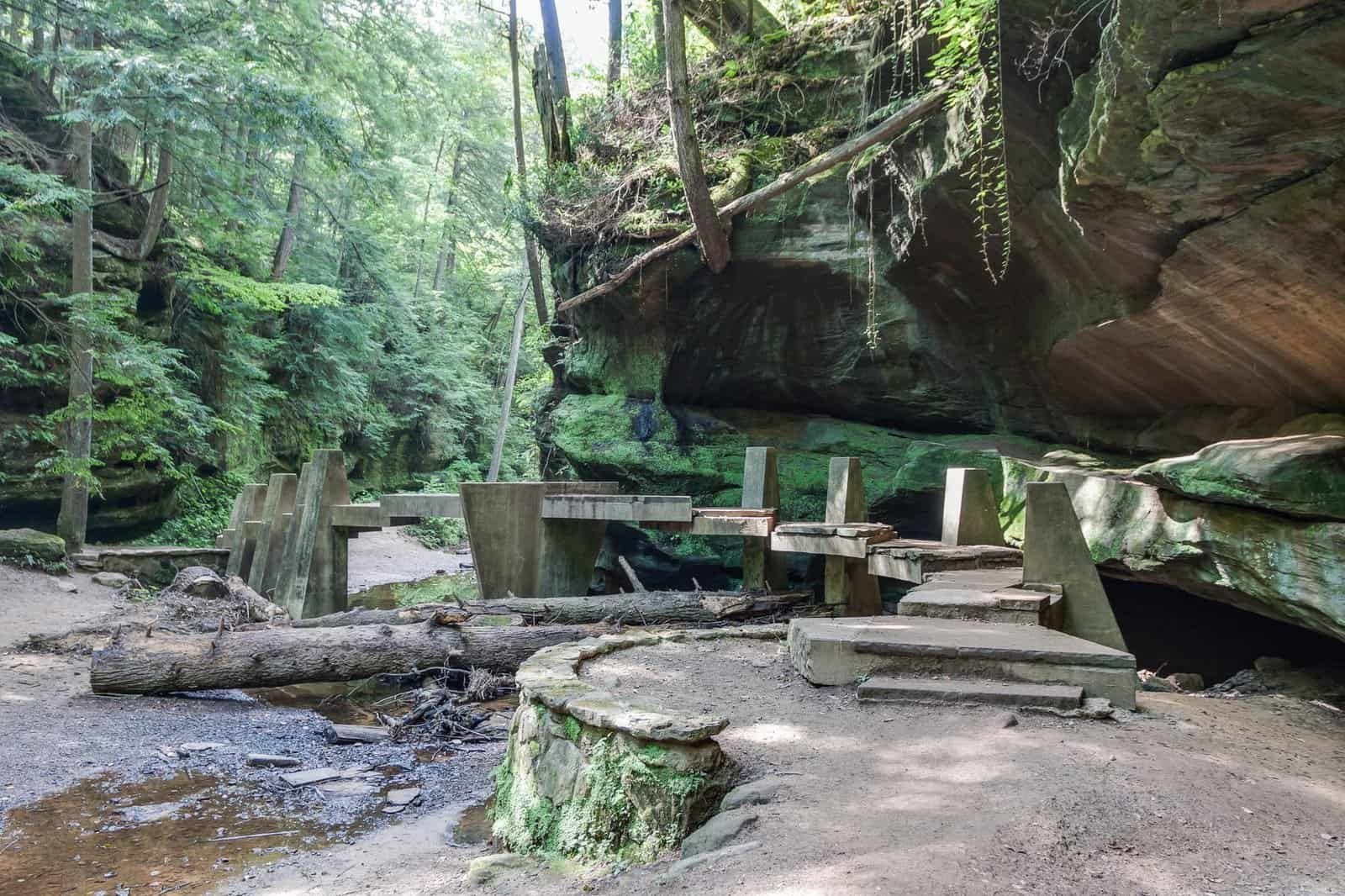 En bro over en bæk i Hocking Hills State Park i en dal med stedsegrønne træer og klippeudhæng