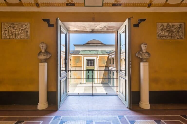 Open classical architecture balcony view with sculptures and murals, historic building design for travel enthusiasts.