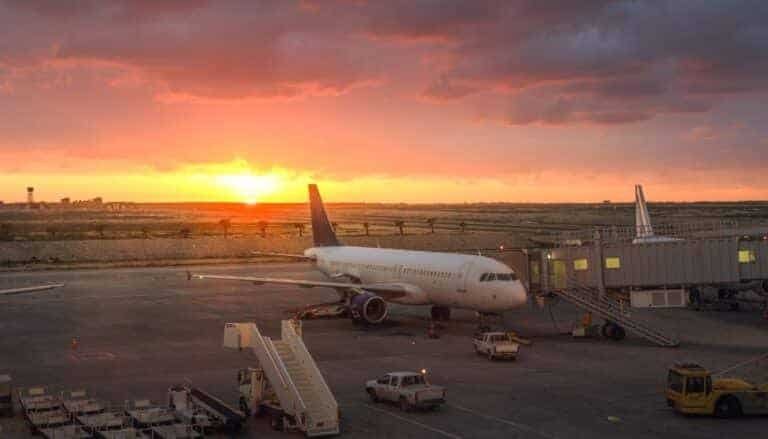 Plane at airport during sunset, travel, vacation, airport runway, air travel, jet aircraft, travel destination, vacation flight, sunset sky, airport terminal.