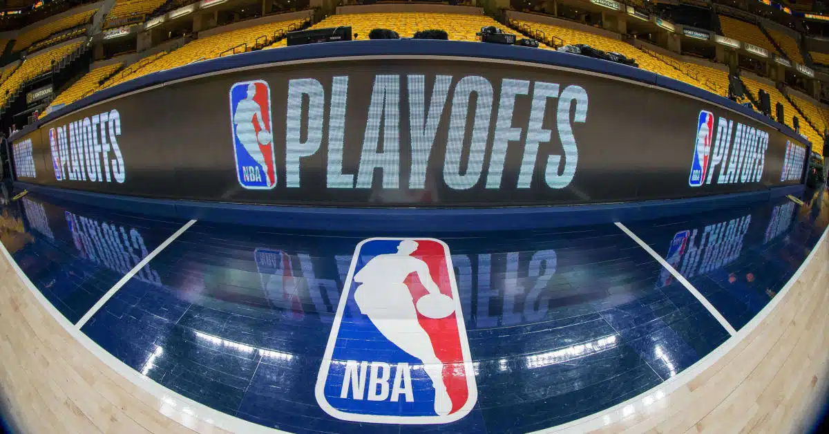 NBA Playoffs basketball court with NBA and NBA Playoffs logos at an empty arena.
